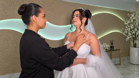 Eleusa ajustando o vestido da noiva, já com tiara e véu